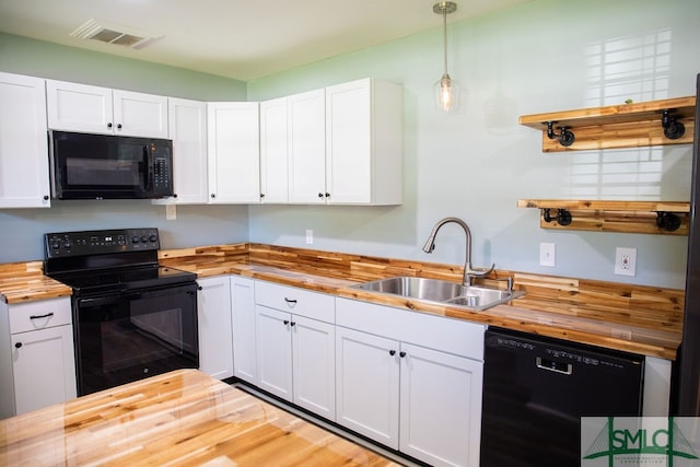 kitchen featuring wooden counters, pendant lighting, white cabinets, sink, and black appliances