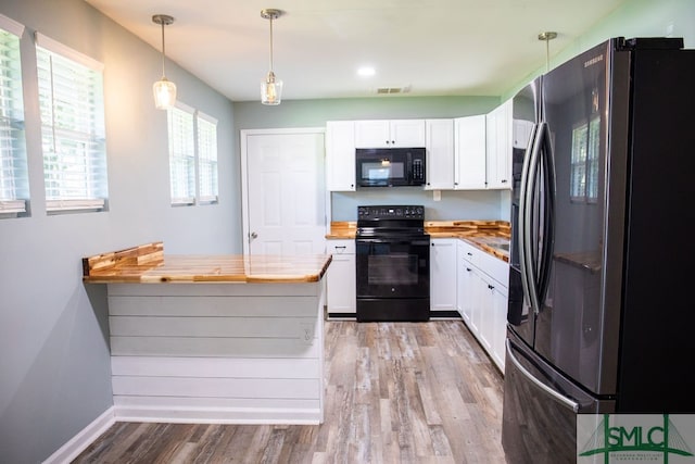 kitchen with white cabinets, kitchen peninsula, hanging light fixtures, and black appliances