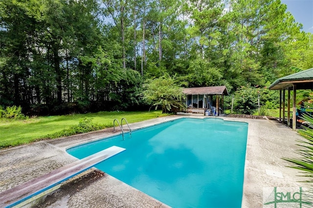 view of pool featuring a diving board and a yard