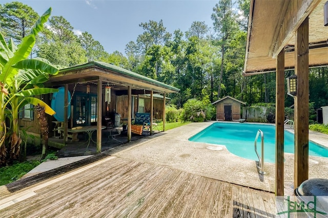 view of swimming pool featuring a patio area and a shed