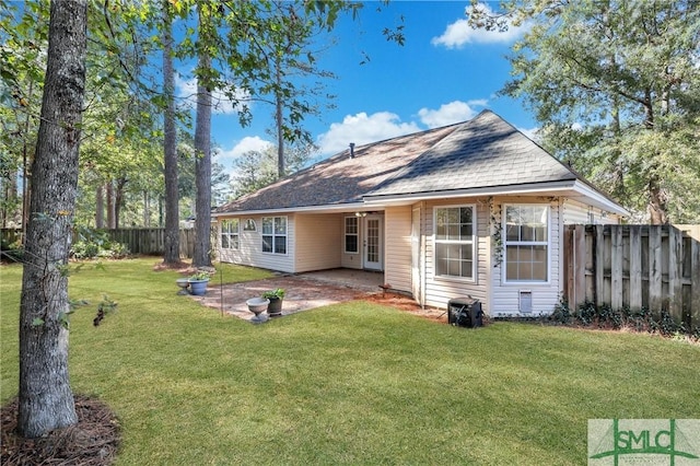 rear view of property featuring a lawn and a patio area