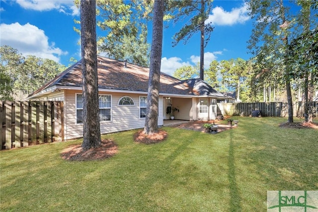 rear view of property featuring a yard and a patio