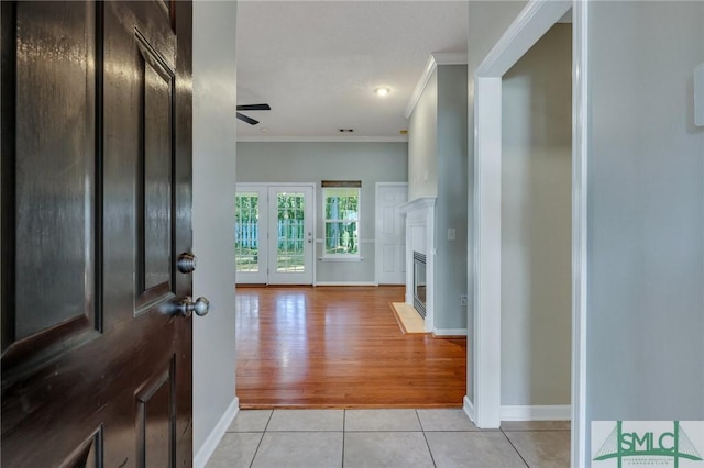 tiled entrance foyer with ceiling fan and ornamental molding