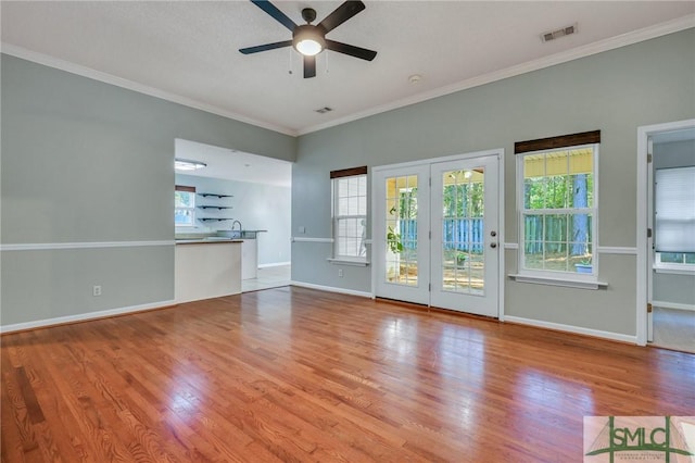 unfurnished living room with ceiling fan, crown molding, and light hardwood / wood-style floors