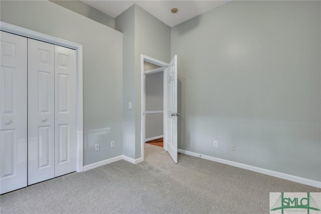 unfurnished bedroom featuring light carpet and a closet