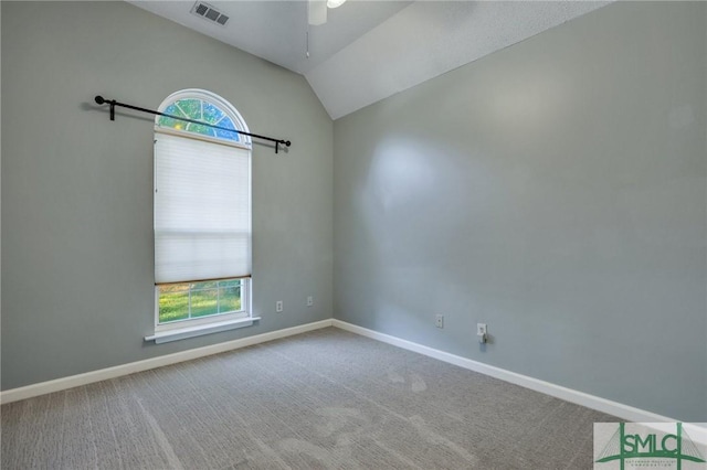 carpeted spare room with ceiling fan and vaulted ceiling