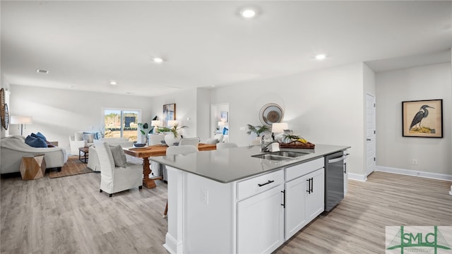 kitchen featuring light hardwood / wood-style flooring, dishwasher, sink, white cabinetry, and a kitchen island with sink