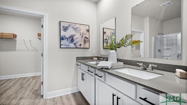 bathroom with hardwood / wood-style flooring, an enclosed shower, and vanity