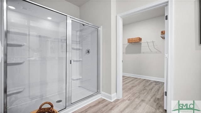 bathroom featuring wood-type flooring and an enclosed shower