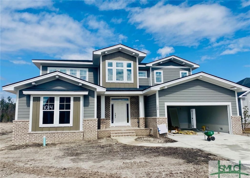 view of front of house featuring driveway, board and batten siding, and brick siding