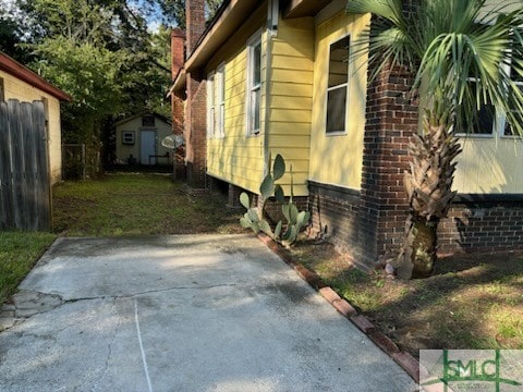 view of side of home with a patio area and a shed