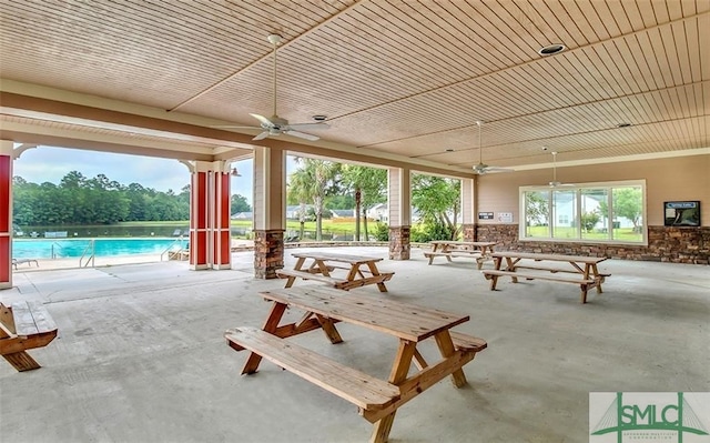 view of patio with ceiling fan and a community pool