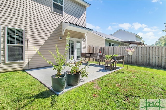 rear view of property featuring a patio area, fence, and a lawn