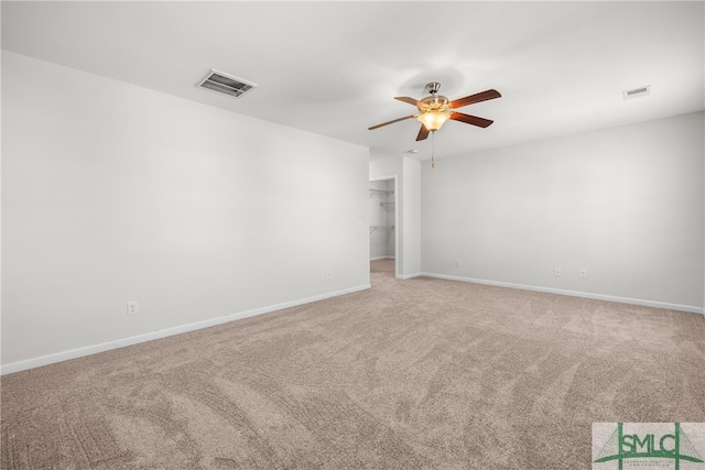 unfurnished room featuring a ceiling fan, light colored carpet, visible vents, and baseboards