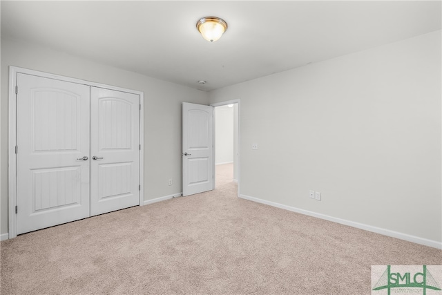 unfurnished bedroom with carpet, baseboards, and a closet