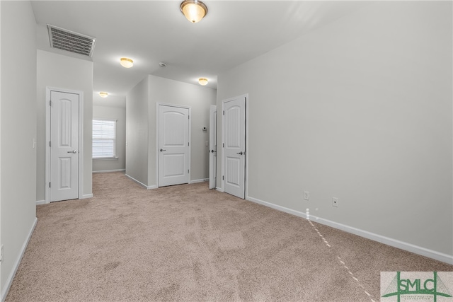 unfurnished bedroom featuring carpet, visible vents, and baseboards