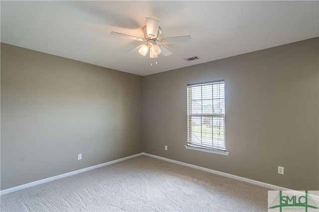 carpeted empty room featuring a ceiling fan, visible vents, and baseboards