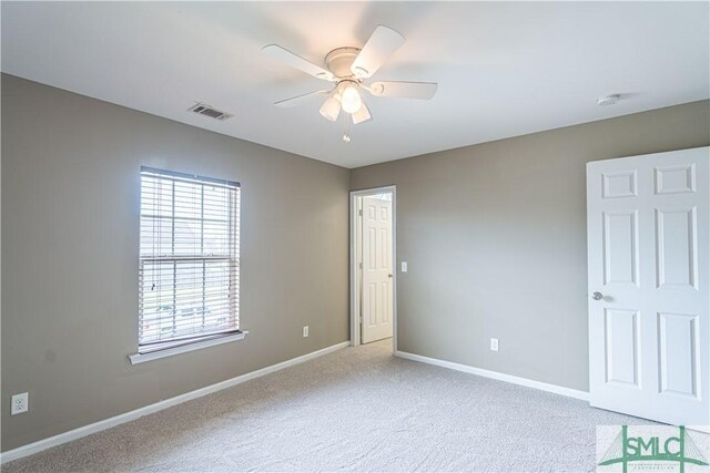 carpeted spare room featuring ceiling fan