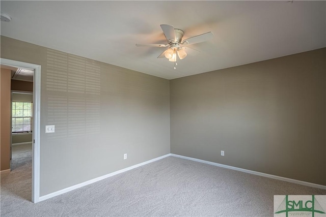 spare room featuring baseboards, a ceiling fan, and light colored carpet