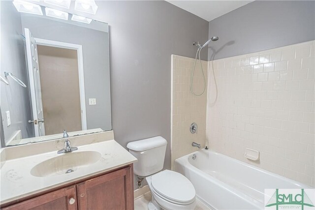 full bathroom featuring tiled shower / bath combo, toilet, and vanity