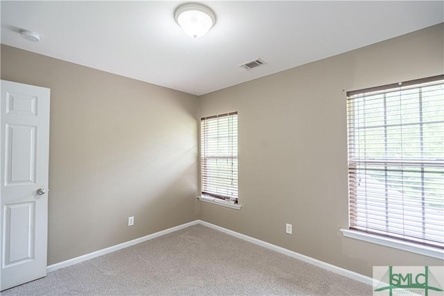 carpeted empty room with baseboards and visible vents