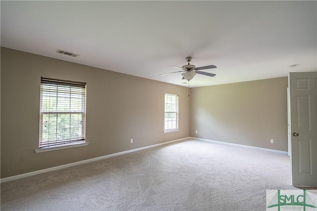 empty room with light carpet, ceiling fan, visible vents, and baseboards