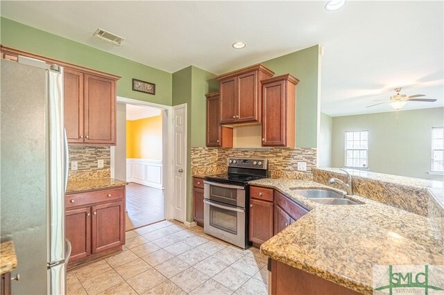 kitchen featuring double oven range, ceiling fan, decorative backsplash, and white refrigerator