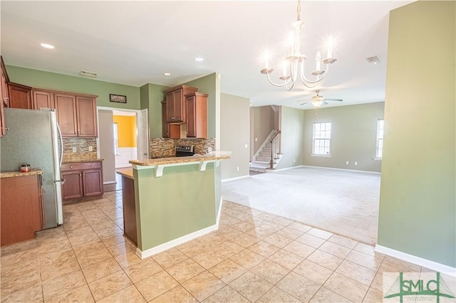 kitchen with open floor plan, light countertops, a breakfast bar, and brown cabinets