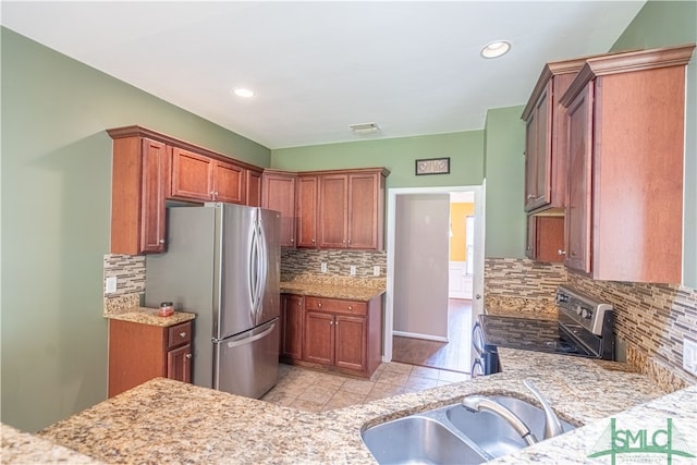 kitchen with sink, electric range oven, light hardwood / wood-style floors, tasteful backsplash, and stainless steel fridge