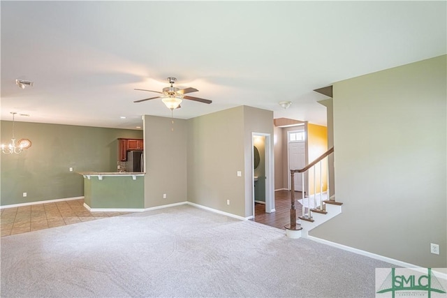 spare room with baseboards, stairway, visible vents, and light colored carpet