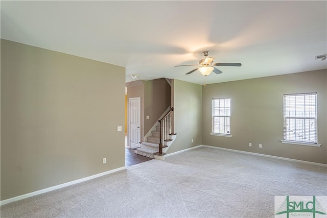 unfurnished room featuring carpet floors, ceiling fan, baseboards, and stairs