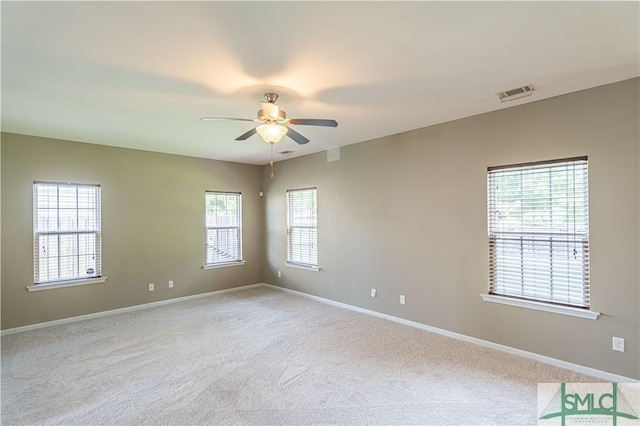 spare room with baseboards, ceiling fan, visible vents, and light colored carpet