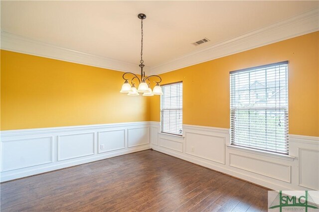 unfurnished room featuring a notable chandelier, crown molding, and dark wood-type flooring