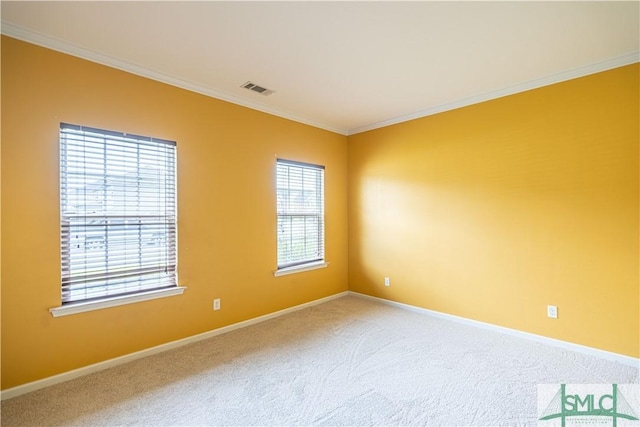 carpeted spare room featuring visible vents, crown molding, and baseboards