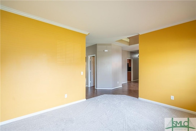 spare room with baseboards, dark colored carpet, and crown molding