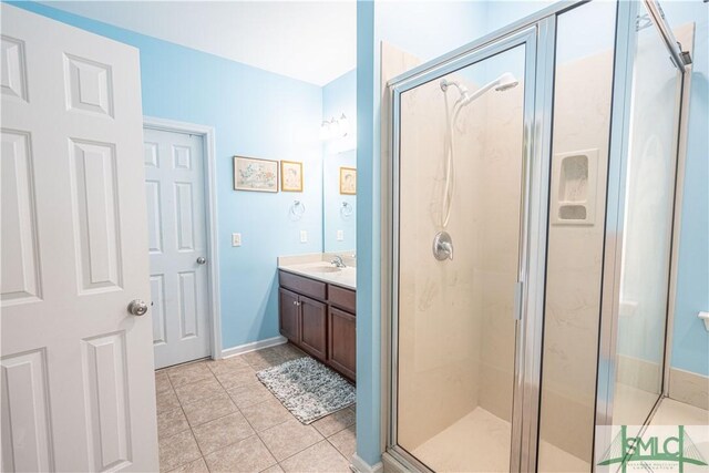 bathroom featuring tile patterned flooring, walk in shower, and vanity