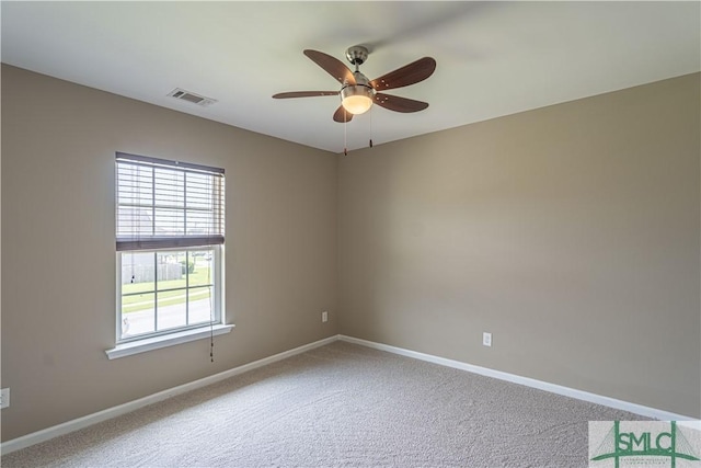 carpeted empty room featuring a ceiling fan, visible vents, and baseboards