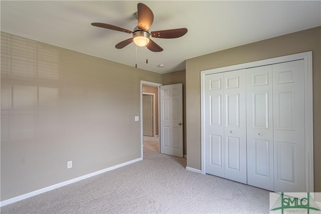 unfurnished bedroom with a closet, light colored carpet, ceiling fan, and baseboards