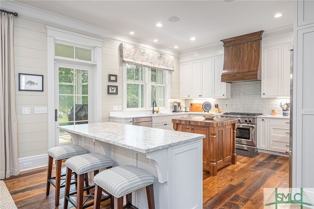 kitchen featuring dark wood-type flooring, a center island, stainless steel appliances, and white cabinetry