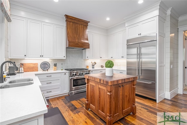 kitchen featuring a center island, premium appliances, sink, and dark hardwood / wood-style floors