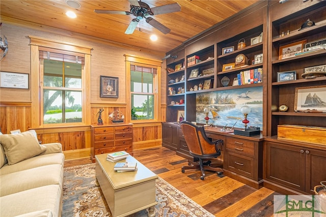 office space featuring wood walls, wood ceiling, ceiling fan, dark hardwood / wood-style floors, and built in shelves