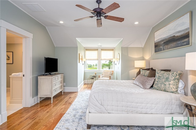 bedroom featuring connected bathroom, light hardwood / wood-style flooring, lofted ceiling, and ceiling fan