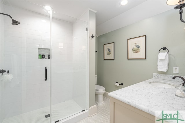 bathroom with vanity, toilet, tile patterned flooring, and a shower with door