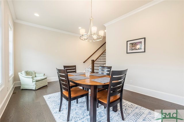 dining space featuring crown molding, hardwood / wood-style flooring, and a chandelier