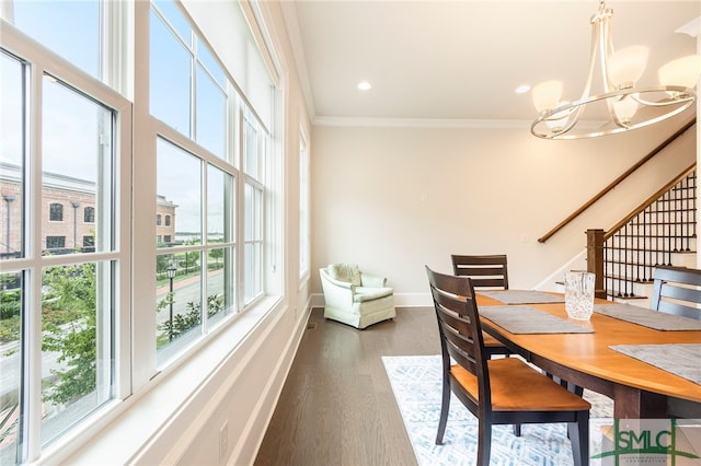 dining space featuring ornamental molding, wood-type flooring, and an inviting chandelier