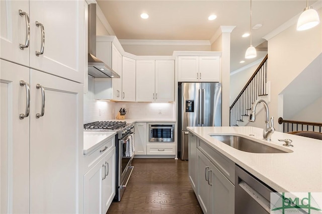 453 Port St, Savannah, GA 31401 - kitchen with stainless steel appliances, wall chimney range hood, ornamental molding, light countertops, and pendant lighting