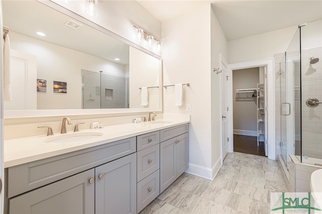 bathroom with tile patterned flooring, walk in shower, and vanity