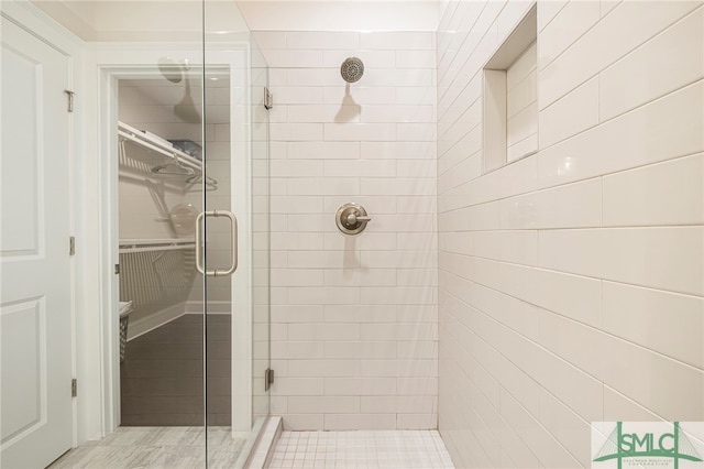 bathroom with a shower with shower door and tile patterned floors