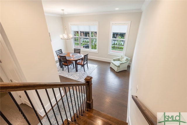 stairs with crown molding, a chandelier, and hardwood / wood-style floors