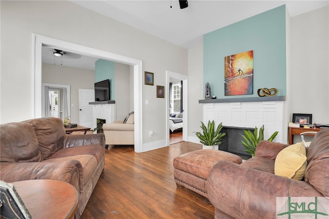 living room featuring a fireplace, dark hardwood / wood-style floors, and ceiling fan